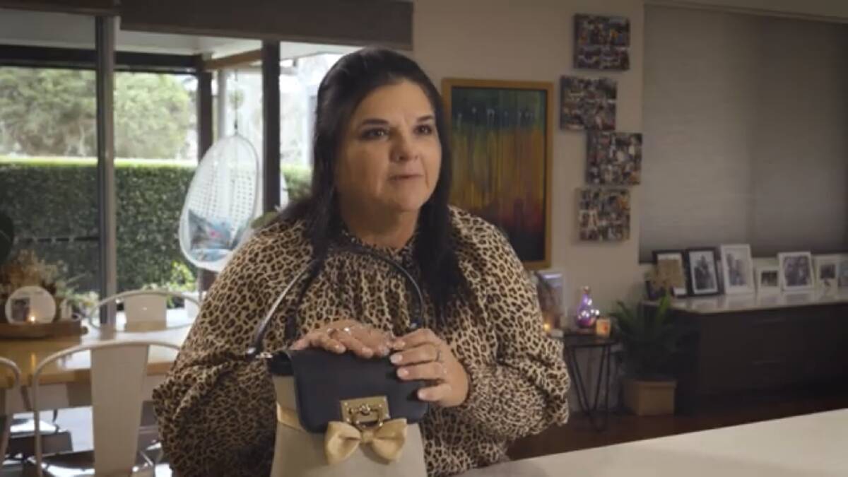 Julie McCabe with the handbag her husband's ashes are stored in. A screenshot from the documentary about palliative care 'Live the life you please'. Picture by Palliative Care Australia